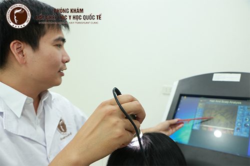 Bác sỹ Tuấn đang kiểm tra nang tóc cho khách hàng